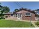 Backyard with a brick house, green lawn, and patio with a door leading outside at 2920 S York St, Denver, CO 80210