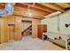 Basement featuring exposed ceiling beams, unfinished stairwell, and storage cabinets at 2920 S York St, Denver, CO 80210