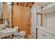 Unfinished basement bathroom with exposed ceiling beams, wooden door and classic toilet and sink at 2920 S York St, Denver, CO 80210