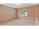 Bedroom featuring neutral carpet, two windows with curtains, and a light fixture at 2920 S York St, Denver, CO 80210