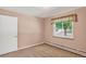 Bedroom with neutral carpet, one window with curtain and a white door at 2920 S York St, Denver, CO 80210