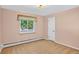 Bedroom with neutral carpet, one window with curtain and a white door at 2920 S York St, Denver, CO 80210