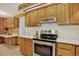 Charming kitchen features oak cabinetry, stainless steel appliances, and white countertops at 2920 S York St, Denver, CO 80210