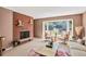 Cozy living room features a brick fireplace, large bay window, and neutral-toned furnishings at 2920 S York St, Denver, CO 80210