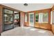 Sunroom featuring tile floor, brick accent wall, and sliding glass door at 2920 S York St, Denver, CO 80210