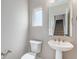 Powder room with pedestal sink, gold hardware and natural light at 888 S Valentia St # 101, Denver, CO 80247