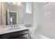 Bathroom showcases a single sink vanity with dark cabinets and a shower-tub combination at 888 S Valentia St # 101, Denver, CO 80247
