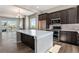 Modern kitchen boasts a large island with a white countertop and dark wood cabinets at 888 S Valentia St # 101, Denver, CO 80247