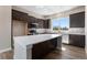 Spacious kitchen featuring a center island, stainless appliances, and dark wood cabinets at 888 S Valentia St # 101, Denver, CO 80247