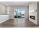 Open concept living room featuring a modern fireplace, wood floors, and sliding doors at 888 S Valentia St # 101, Denver, CO 80247