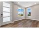 Versatile room with modern wood floors, natural light, and a stylish modern door at 888 S Valentia St # 101, Denver, CO 80247