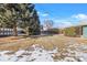 Large backyard with mature trees, partially covered in snow at 4830 W Vassar Ave, Denver, CO 80219