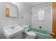 Bathroom with mint green tub and patterned tile at 4830 W Vassar Ave, Denver, CO 80219