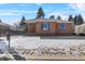 Brick ranch home with snowy lawn and carport at 4830 W Vassar Ave, Denver, CO 80219