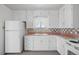 White kitchen cabinets, pink countertops, and appliances at 4830 W Vassar Ave, Denver, CO 80219