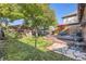 Private backyard featuring a lush lawn, mature trees, detached garage and a wooden deck with outdoor seating at 1335 S Sherman St, Denver, CO 80210