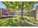 Serene backyard features a well-maintained lawn, mature trees, brick patio, and ample space for relaxation at 1335 S Sherman St, Denver, CO 80210