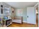 Light-filled Bedroom featuring a wood crib, neutral decor, and hardwood floors at 1335 S Sherman St, Denver, CO 80210