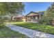 Street view of the brick home featuring a well-manicured lawn, sidewalk, and mature trees at 1335 S Sherman St, Denver, CO 80210