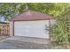 Detached garage with a white door, partial brick wall, and ample space for parking and storage at 1335 S Sherman St, Denver, CO 80210