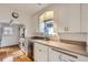 Charming kitchen with white cabinetry, bright counters, and view to the connecting room at 1335 S Sherman St, Denver, CO 80210