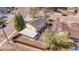 Aerial view of the backyard with a covered patio, fencing, and mature trees at 140 Lane Ct, Fort Lupton, CO 80621