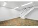 Finished basement with tile flooring and white staircase at 140 Lane Ct, Fort Lupton, CO 80621