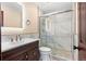 Updated bathroom featuring a glass-enclosed shower with marble tiling, and a dark wood vanity with modern hardware at 140 Lane Ct, Fort Lupton, CO 80621