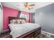 Bedroom with wood floors, pink walls, a window, a ceiling fan, and a bed with lots of pillows at 140 Lane Ct, Fort Lupton, CO 80621