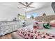 Bedroom with a bright window, a large dresser with vanity, laminate flooring, and a ceiling fan at 140 Lane Ct, Fort Lupton, CO 80621