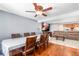 Open floor plan with hardwood dining area and an adjacent seating area and a ceiling fan at 140 Lane Ct, Fort Lupton, CO 80621
