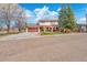 Inviting two-story home featuring a covered front porch and a freshly sealed driveway, all set against a blue sky with fluffy clouds at 140 Lane Ct, Fort Lupton, CO 80621