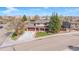 Charming two-story home with a covered front porch and a well-maintained front yard, complemented by mature trees and a paved driveway at 140 Lane Ct, Fort Lupton, CO 80621