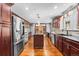 Contemporary kitchen boasting stainless steel appliances, custom wood cabinets, granite counters, and an island, perfect for entertaining at 140 Lane Ct, Fort Lupton, CO 80621