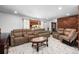 Spacious living room featuring marble tile, a brick accent wall and access to front door at 140 Lane Ct, Fort Lupton, CO 80621