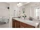 Bright bathroom featuring a double sink vanity with granite countertop and dark wood cabinets at 4343 S Nepal Ct, Centennial, CO 80015