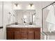 Bathroom featuring a double sink vanity with granite countertop and dark wood cabinets at 4343 S Nepal Ct, Centennial, CO 80015