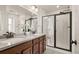 Modern bathroom with dual sinks, granite countertop, dark wood cabinets, and glass-enclosed shower at 4343 S Nepal Ct, Centennial, CO 80015