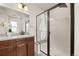 Modern bathroom with dark wood cabinets, granite countertop, sink, and a glass-enclosed shower at 4343 S Nepal Ct, Centennial, CO 80015