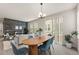 Bright dining area with wood table, blue chairs, open to the living room and outside area at 4343 S Nepal Ct, Centennial, CO 80015