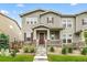 Charming two-story townhouse featuring a covered porch, stone accents, and landscaped front yard at 4343 S Nepal Ct, Centennial, CO 80015