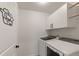 Laundry room featuring modern washer and dryer, storage cabinets and custom sign at 4343 S Nepal Ct, Centennial, CO 80015