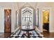 Grand foyer featuring a checkered floor, arched ceilings, and elegant chandelier at 9042 E Vassar Ave, Denver, CO 80231