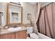 Bathroom with a sink and vanity with wood cabinets, a large mirror, and a shower-tub combo at 9218 Viaggio Way, Highlands Ranch, CO 80126