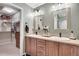 Bathroom featuring double sinks with stylish mirrors and an open walk-in closet at 9218 Viaggio Way, Highlands Ranch, CO 80126