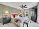 Comfortable bedroom with a ceiling fan, upholstered headboard, and a decorative accent wall at 9218 Viaggio Way, Highlands Ranch, CO 80126
