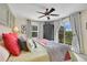 Bedroom featuring a private balcony, ceiling fan, and stylish patterned curtains at 9218 Viaggio Way, Highlands Ranch, CO 80126