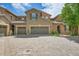 Exterior showcasing garages, brick driveway and manicured front yard at 9218 Viaggio Way, Highlands Ranch, CO 80126