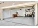 Spacious garage with coated flooring, storage shelving, and a white interior door to the home at 9218 Viaggio Way, Highlands Ranch, CO 80126