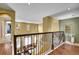 Hallway with a decorative iron railing overlooking the living room, providing an open and airy feel at 9218 Viaggio Way, Highlands Ranch, CO 80126